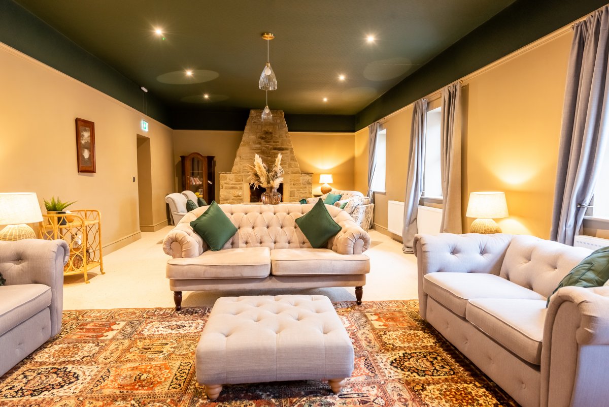 Blackton Grange - lounge with luxury sofas one side with smart TV, one with log burning stove